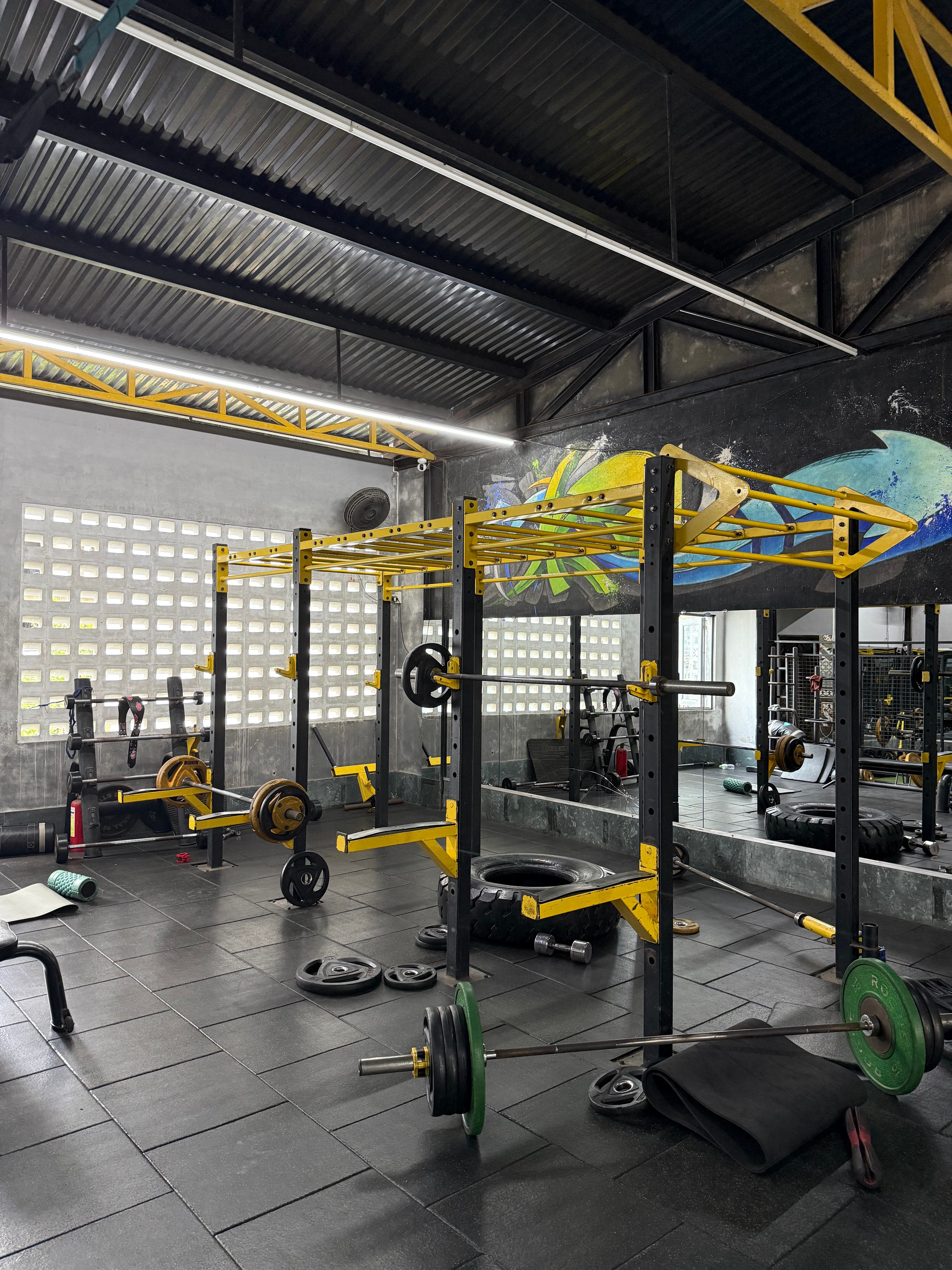 Squat racks with loaded barbells and bumper plates on the rubber floor