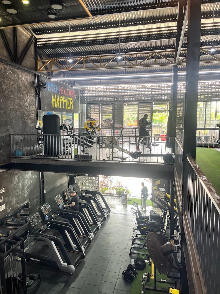 The upstairs walkway with the cardio row and the heavy bag, looking down over the ground floor